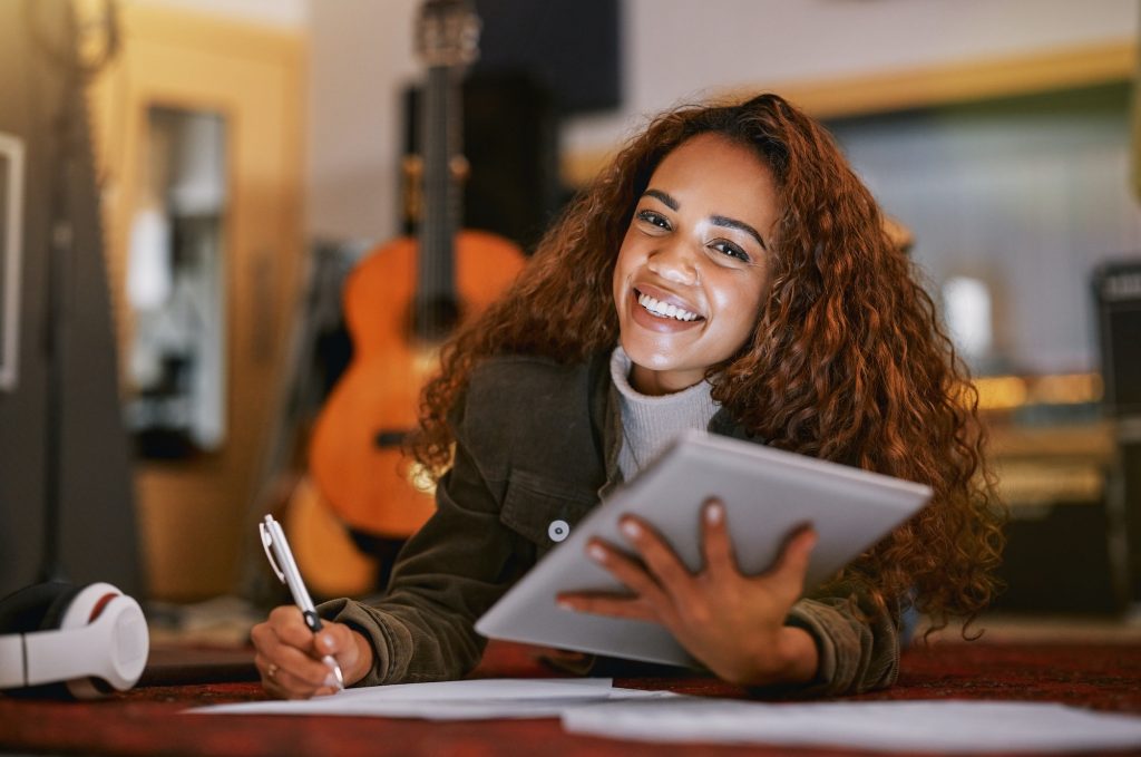 Black woman, portrait smile and tablet writing music in studio for audio track, content creation or